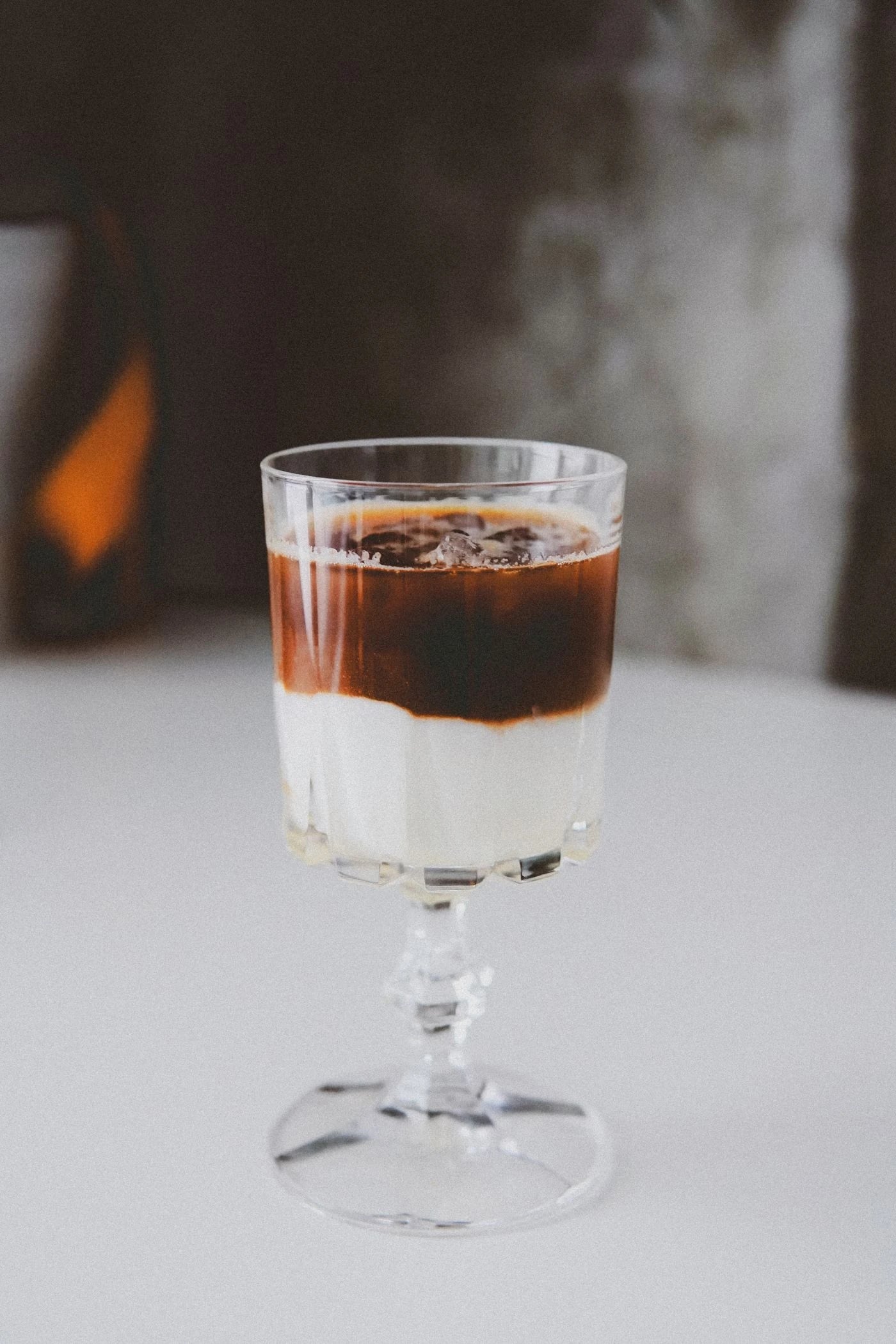 Layered iced coffee and milk in a complete glass